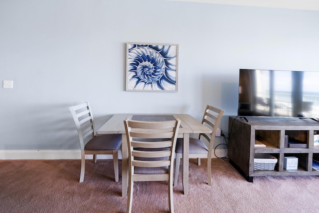 carpeted dining room with baseboards