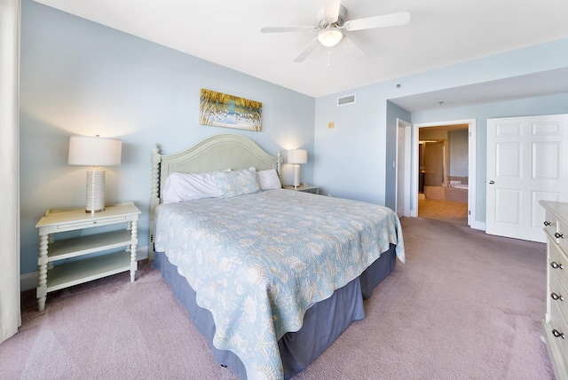 bedroom with ensuite bathroom, carpet floors, visible vents, baseboards, and a ceiling fan