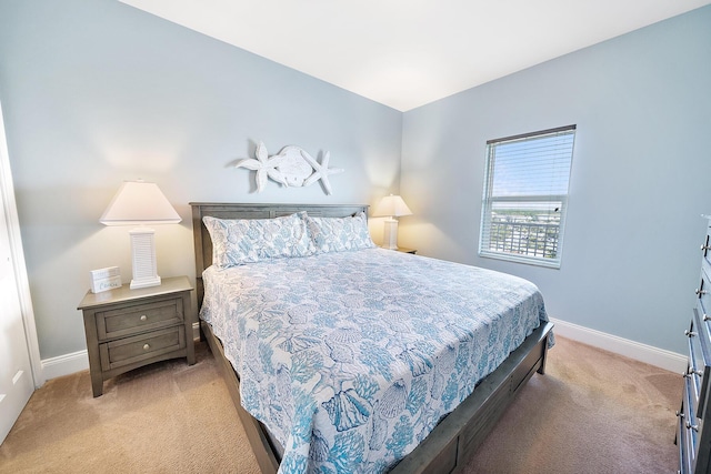 bedroom with light colored carpet and baseboards