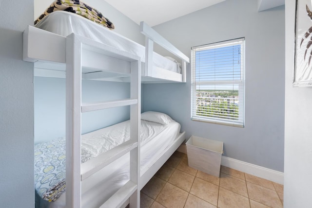 bedroom featuring light tile patterned floors and baseboards