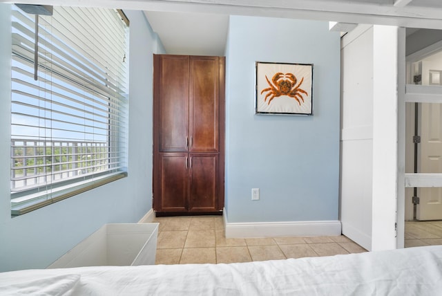 bedroom with light tile patterned floors and baseboards