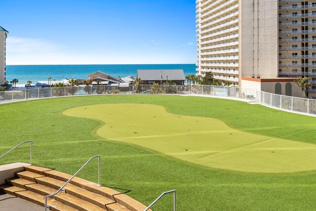 view of home's community featuring a water view, view of golf course, and fence