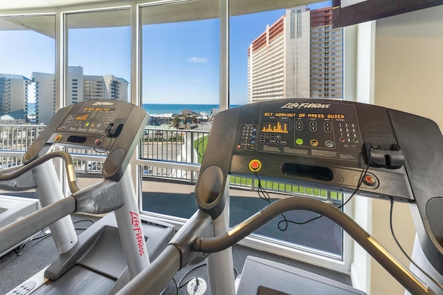 workout area with a water view and a city view