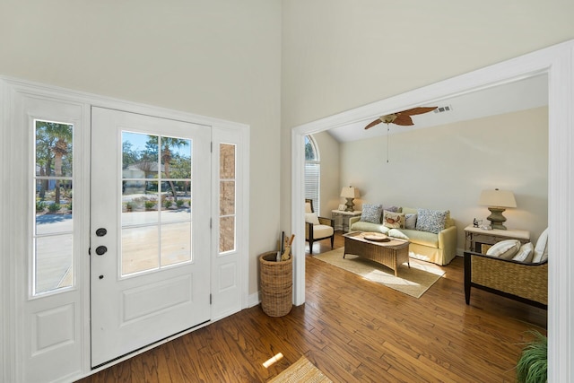 entrance foyer featuring visible vents, wood finished floors, a towering ceiling, and a ceiling fan