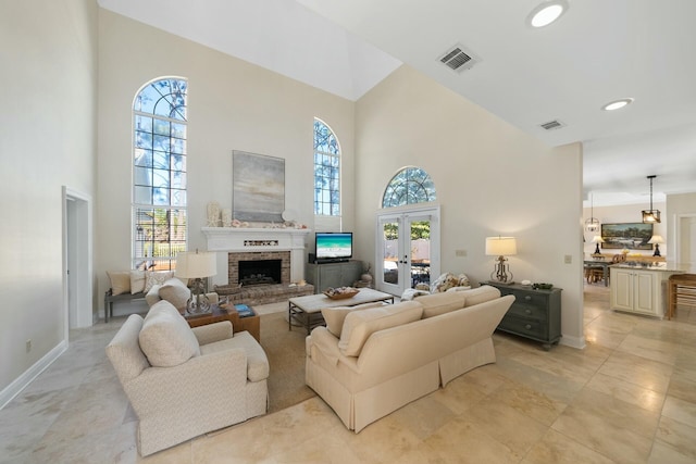 living area with a wealth of natural light, a brick fireplace, and visible vents