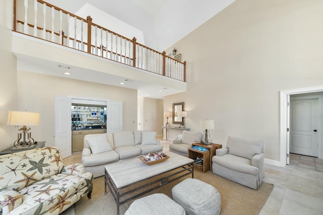 living room featuring baseboards, visible vents, and a high ceiling