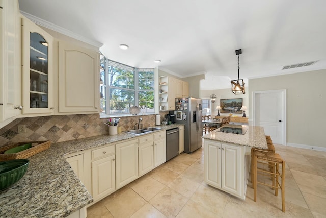 kitchen with a center island, decorative light fixtures, stainless steel appliances, visible vents, and a sink