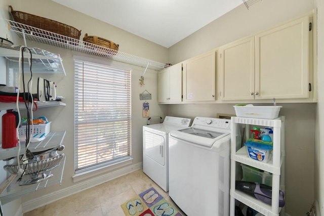 laundry room with cabinet space, light tile patterned floors, visible vents, baseboards, and washing machine and clothes dryer