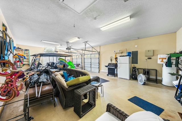 garage featuring electric panel, baseboards, and freestanding refrigerator