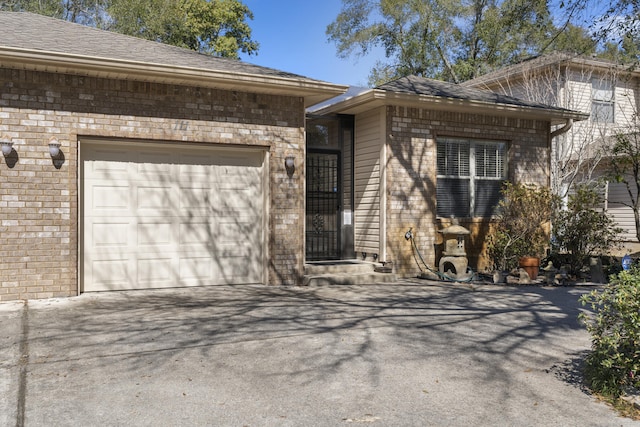 view of front facade featuring a garage, driveway, and brick siding