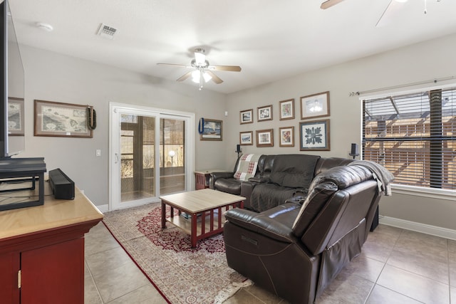 living area with light tile patterned floors, plenty of natural light, and a ceiling fan