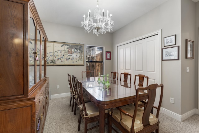 dining space with baseboards, an inviting chandelier, and light colored carpet