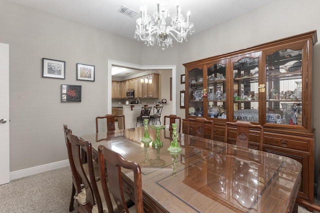 dining room featuring a chandelier, carpet flooring, visible vents, and baseboards