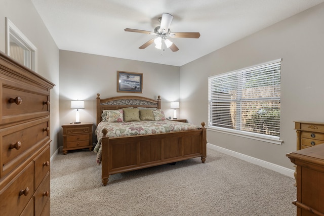 bedroom with light carpet, ceiling fan, and baseboards