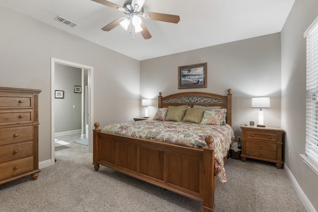 bedroom featuring light colored carpet, ceiling fan, visible vents, and baseboards