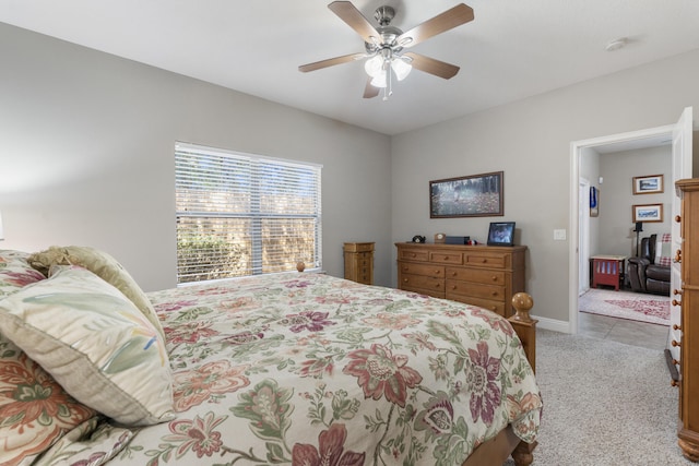 bedroom with a ceiling fan, light colored carpet, and baseboards