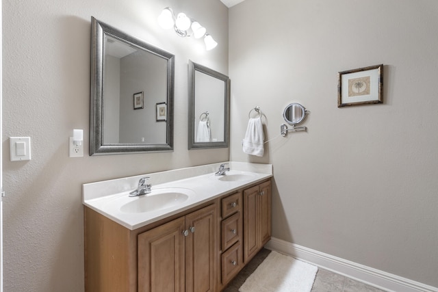 full bathroom with a sink, baseboards, and double vanity