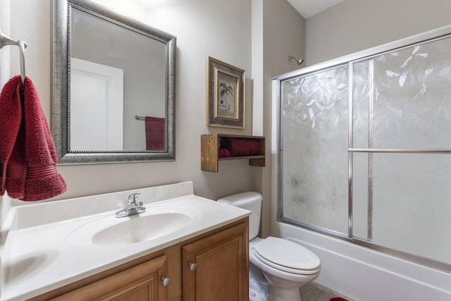 bathroom featuring toilet, bath / shower combo with glass door, and vanity