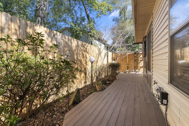 wooden terrace with a fenced backyard