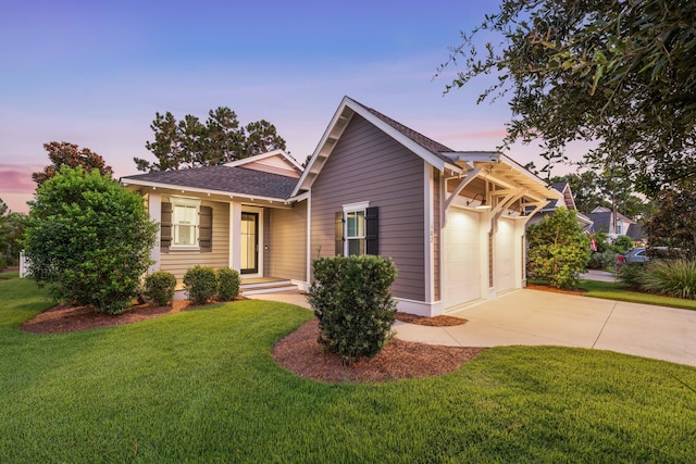 view of front of home featuring a garage, driveway, and a yard