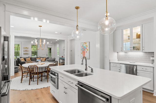 kitchen featuring appliances with stainless steel finishes, white cabinetry, and a sink