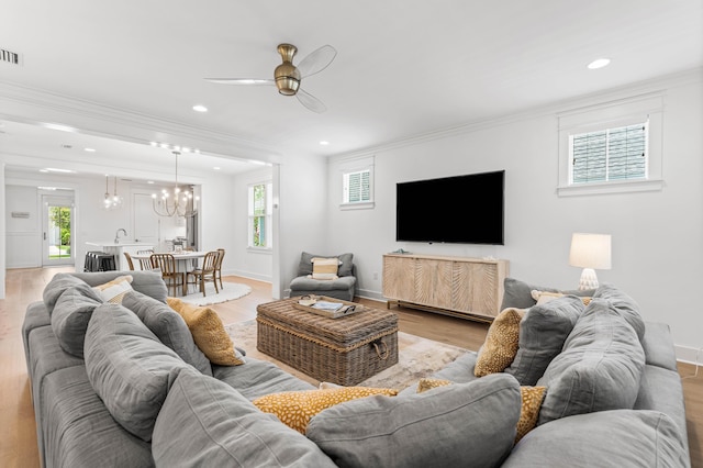 living room with recessed lighting, ceiling fan with notable chandelier, baseboards, light wood-style floors, and ornamental molding