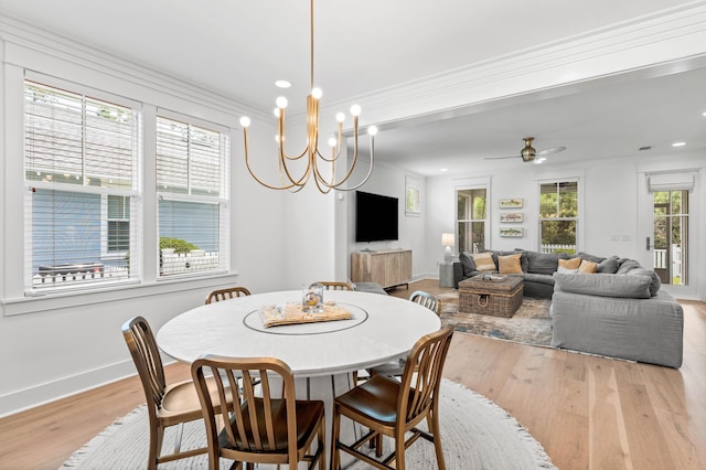 dining area featuring light wood-type flooring, crown molding, and baseboards