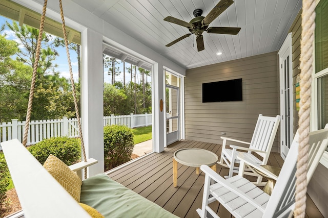 sunroom / solarium with a ceiling fan and wooden ceiling