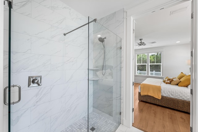 ensuite bathroom with a stall shower, wood finished floors, ceiling fan, and ensuite bathroom