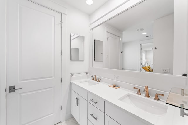 full bathroom with double vanity, ensuite bathroom, a sink, and recessed lighting