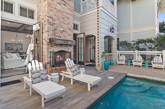 exterior space with a brick fireplace and a wooden deck