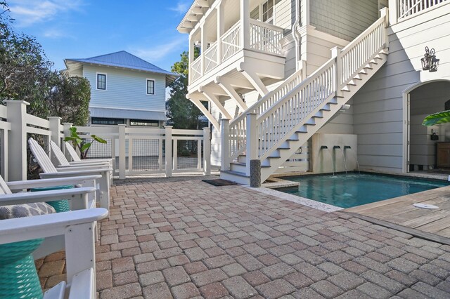 view of swimming pool with a fenced in pool, a patio area, and stairs