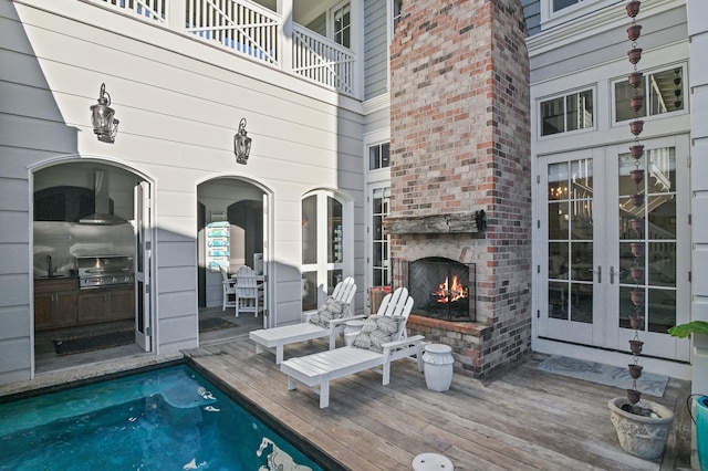 exterior space with french doors, an outdoor brick fireplace, and a grill