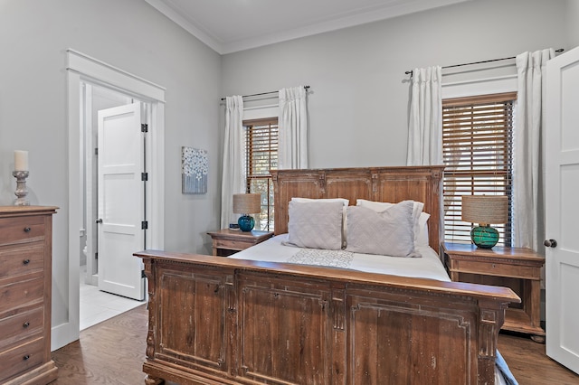 bedroom featuring ornamental molding, connected bathroom, and wood finished floors