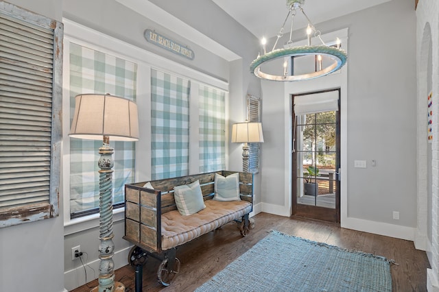 foyer with an inviting chandelier, baseboards, and wood finished floors