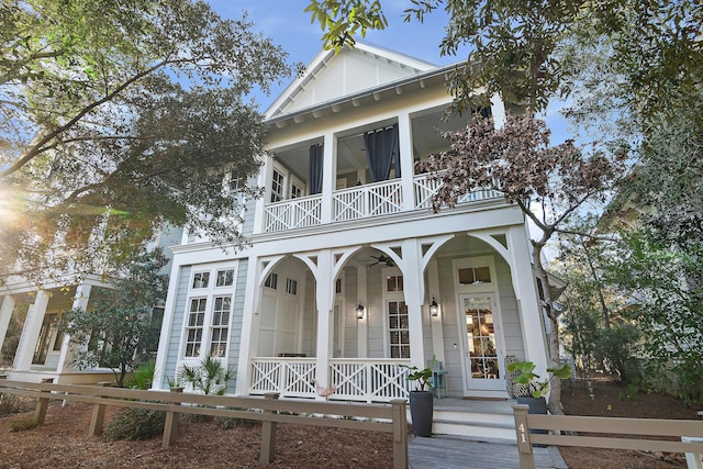 greek revival house featuring a balcony, a fenced front yard, ceiling fan, and a porch