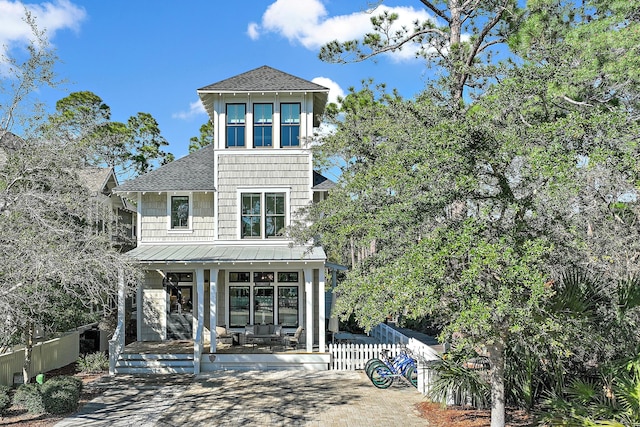 view of front of house featuring a fenced front yard, a porch, and roof with shingles