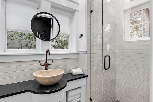 full bath featuring a stall shower, backsplash, and vanity