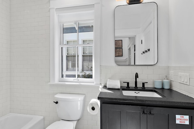 bathroom with toilet, plenty of natural light, a bathtub, and tile walls