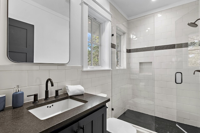 bathroom featuring tile walls, a shower stall, vanity, and toilet