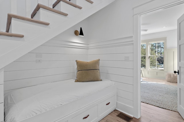 mudroom with light wood-style flooring, visible vents, and a decorative wall