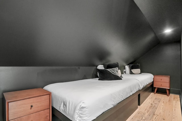 bedroom with lofted ceiling, light wood finished floors, and recessed lighting