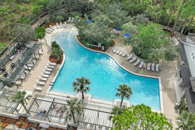 pool with a patio area and fence