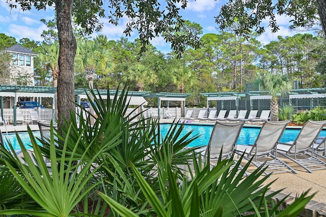 community pool with fence and a pergola