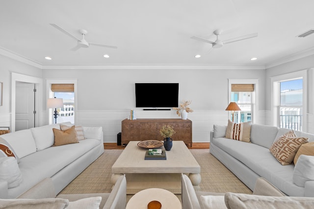 living room with a healthy amount of sunlight, ceiling fan, and wainscoting