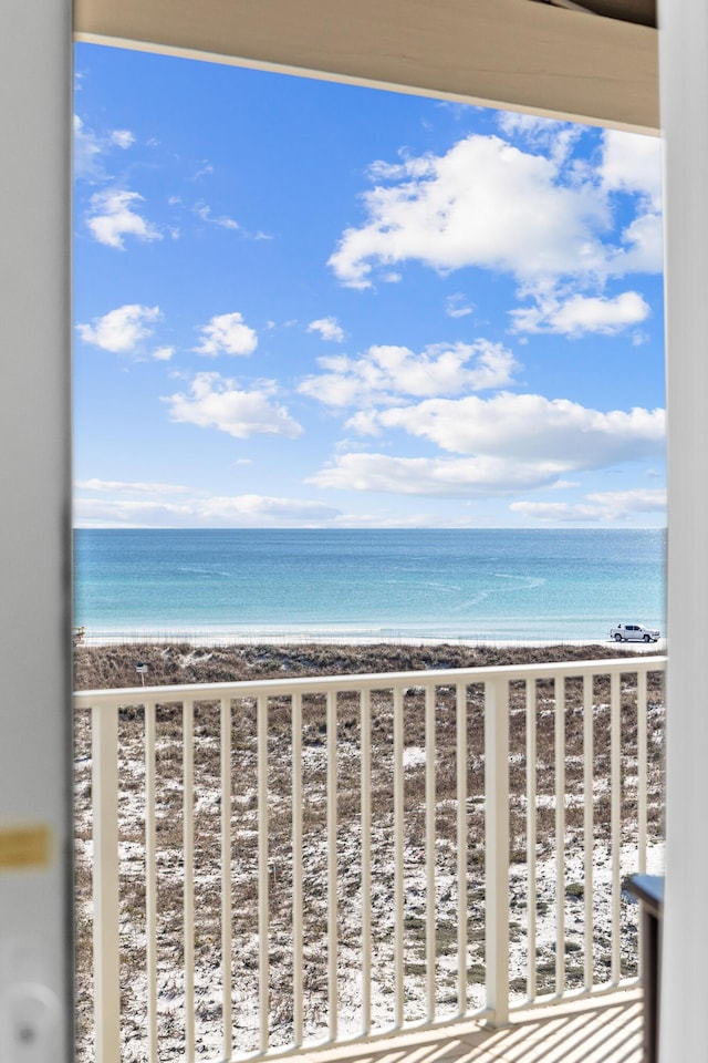 balcony featuring a water view and a beach view