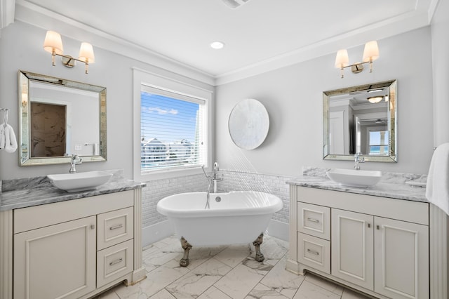 bathroom featuring a soaking tub, a wainscoted wall, a sink, and marble finish floor