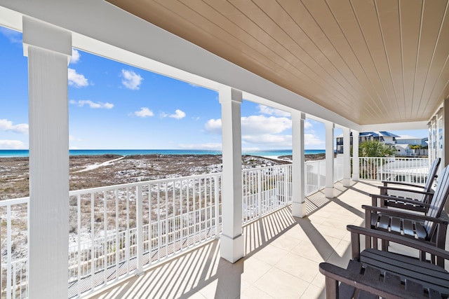 balcony with a water view and a view of the beach