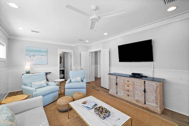 living room with visible vents, wood finished floors, and wainscoting