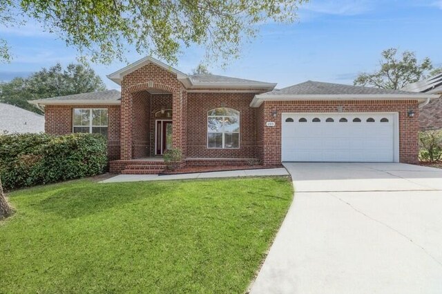 single story home featuring concrete driveway, brick siding, an attached garage, and a front yard